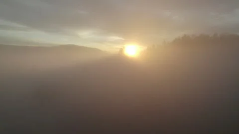 Drone flying through clouds over forest at sunrise, cinematic alpine landscape Stock Footage 325207978