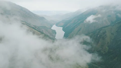 Drone flying through clouds in the sky and fog, appearance of mountains and lake Stock Footage 219418031