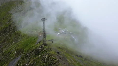 Drone flying through clouds towards to group of cars on mountain peak Video stock 229835408