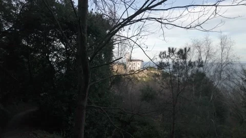 Drone flying through a dark forest path towards Getaria lighthouse in Basque Vídeos de archivo 334248315