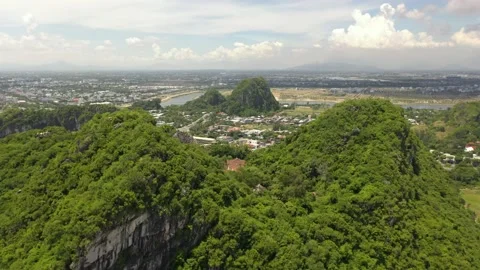 Drone flying through famous Marble Mountains with Temple, caves, cliffs Stock Footage 220007368