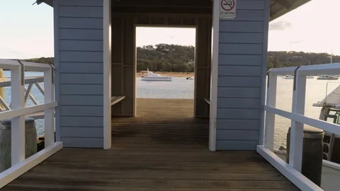Drone flying through hut and over water looking at yacht Stock Footage 128277075