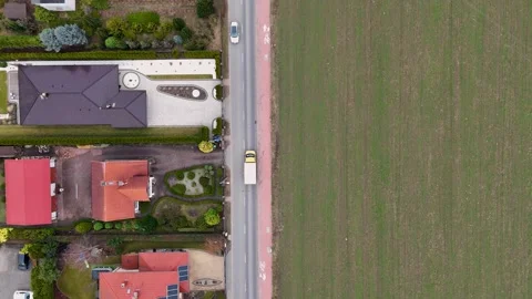 Drone Flying Top Down Following White Van On Road Between Houses And Field Stock Footage 330750546