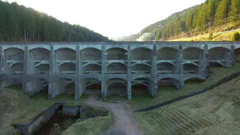 Drone flying toward dam and rising above, cinematic aerial reveal of reservoir Video stock 333069077