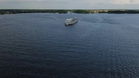 Drone flying toward large ship on wide river Video stock 333544649