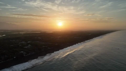 Drone Flying Toward Pacific Ocean at Sunrise Above Tropical Black Sand Coastline Video stock 337914735
