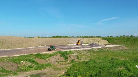 Drone flying towards an excavator working at a junkyard Stock Footage 314213486