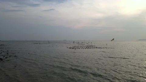 Drone flying towards the flag was hoisted on a rock in the middle of the sea Stock Footage 150723573