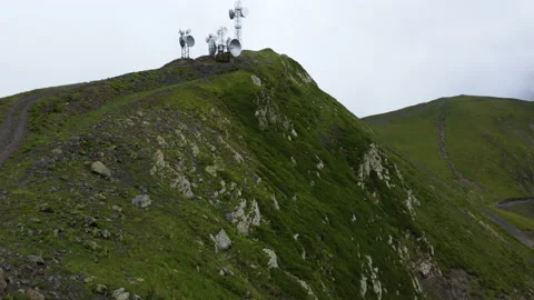 Drone flying towards to peak of mountain with satellite towers Stock Footage 229858515