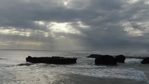 Drone flying towards rocks cloudy sun 動画素材 303639039