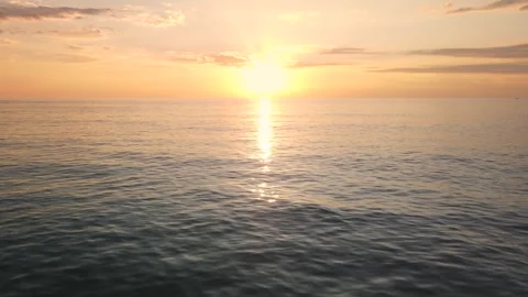 Drone flying towards sunset over water, slow rise Stock Footage 291887194
