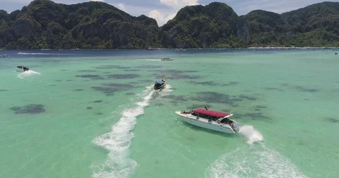 Drone flying under the boats and amazing clear water at Phi-Phi island. Aerial Video stock 75767933