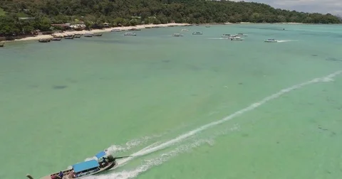 Drone flying under the boats and amazing clear water at Phi-Phi island. Aerial Video stock 75768066