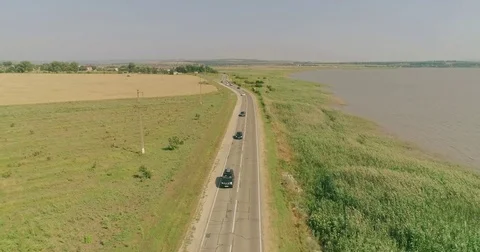 Drone flying under the long road between the fields and lake, top view. Drone Stock Footage 78941867