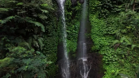 Drone flying upwards in front of a double waterfall in the forest in 4k Vídeos de archivo 348111367