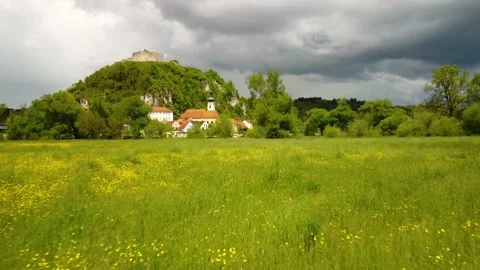 Drone flying very low over blooming summer meadow towards Kallmuenz, Bavaria on Stock Footage 154419978