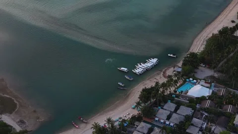 Drone Flyover Above Beachfront Resort and Moored Speedboats Vidéo 336389523