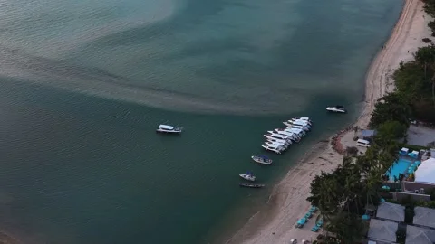 Drone Flyover Above Beachfront Resort and Moored Speedboats Stock Footage 336389813