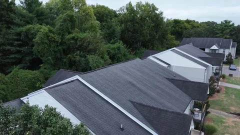 Drone flyover across apartment building rooftops on overcast day Stock Footage 346732041