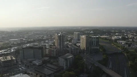 Drone flyover of a highway next to a few buildings at sunrise Stock Footage 167559633