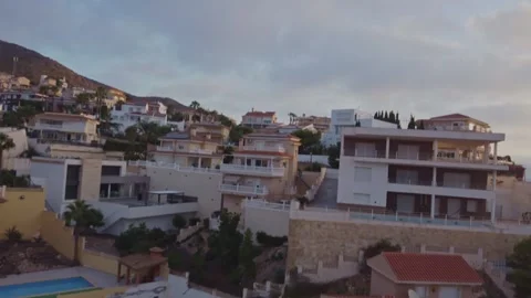 Drone Flyover of Hillside Luxury Villas Ending on Woman Exercising by Pool Stock Footage 345385763