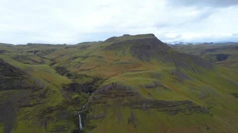 Drone flyover of Írá́rfoss Waterfall, revealing the rugged volcanic landscape 動画素材 346654749