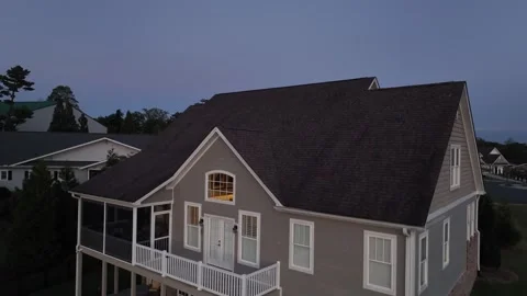 Drone flyover large American suburban house at dusk, with gray siding, white Stock Footage 317237039
