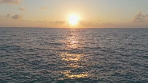 Drone flyover of the ocean at sunrise, with rolling waves in shades of blue.. Stock Footage 285597512