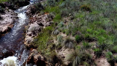 Drone flyover of overflow stream from dam wall in open landscape Stock Footage 333719587
