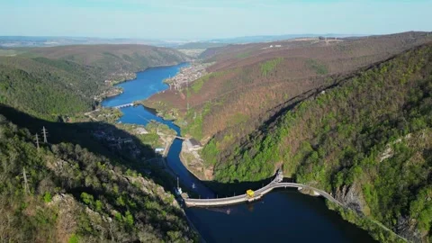 Drone Flyover of Rolling Hills with River and Visible Dam Stock Footage 299711160
