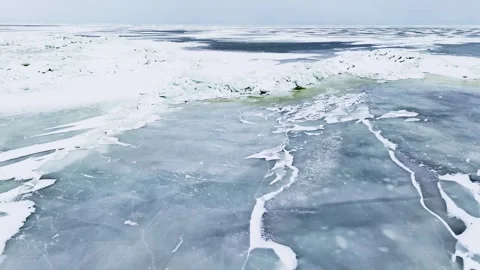 Drone flyover of sea-ice pressure ridge with green meltwater channel and Stock Footage 332736622