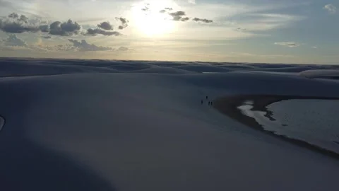 Drone flyover toward the sun above Lençóis Maranhenses dunes, Brazil Video stock 328190522