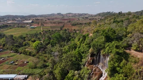 Drone Flyover Waterfall in Tropical Mountain Forest with Rural Landscape and Blu Stock Footage 328276797