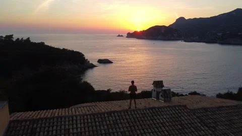 Drone Flypast of Man on Rooftop at Sunset, Liapades, Corfu Stock Footage 337732211