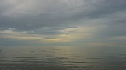 Drone fly’s camera and into a cloudy grey sky above a very large lake  Stock Footage 155129019