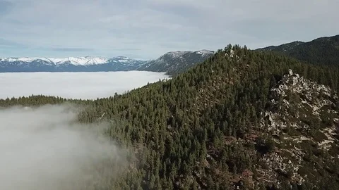 Drone flys over mountain showing lake covered in fog Stock Footage 83229375