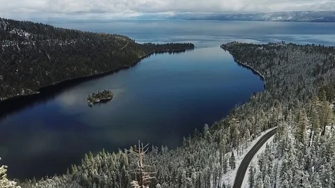 Drone flys through snowy trees to emerald bay Stock Footage 83229324