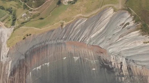 Drone flysch sea stack rock lines formation beach stones Stock Footage 221572368