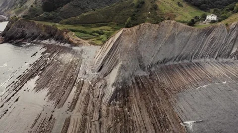 Drone flysch sea stack rock lines formation beach stones Stock Footage 221572371