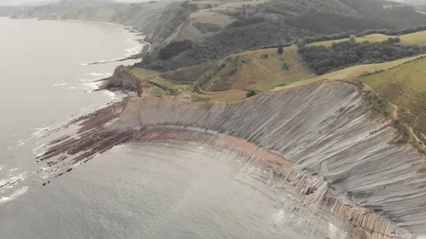 Drone flysch sea stack rock lines formation beach stones Stock Footage 221572375