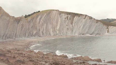 Drone flysch sea stack rock lines formation beach stones Stock Footage 221572401