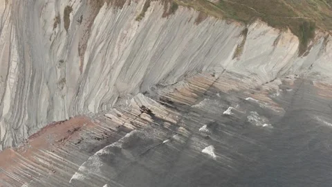 Drone flysch sea stack rock lines formation beach stones Stock Footage 221572413