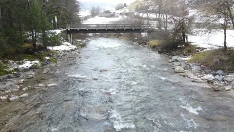 Drone flythrough under alpine bridge above mountain stream Stock Footage 331900200