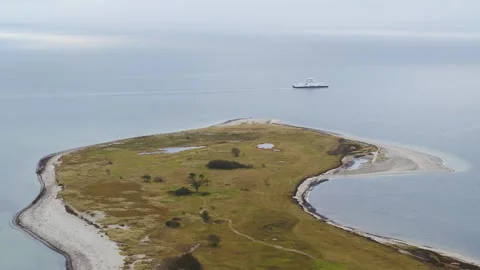 Drone follow small ferry passing a small island in Denmark Stock Footage 314213517