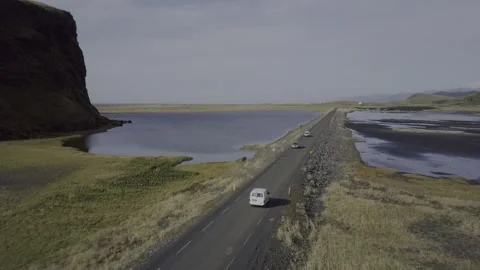 Drone follow white van over a road surrounded by water in Iceland. Video stock 143828233