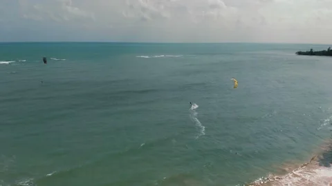 Drone following man practicing kite surfing and windsurfing on deep blue sea Stock Footage 229677523