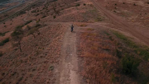 The drone following of a man riding an adventure-class motorcycle in a daytime Stock Footage 257552853