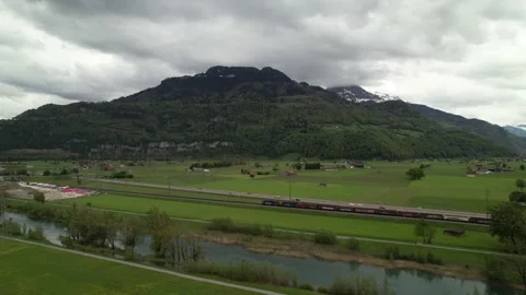 Drone following a moving train driving into a beautiful mountain lake panorama. Stock Footage 155191743
