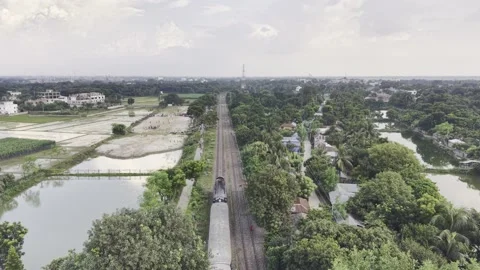 Drone following a passenger train along rural railway tracks Stock Footage 344544424