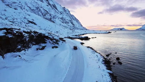 Drone following shot of a large SUV driving over a frozen road in the Video stock 263289846